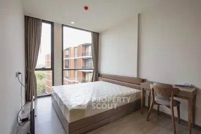 Modern bedroom with large windows and natural light in a contemporary apartment.