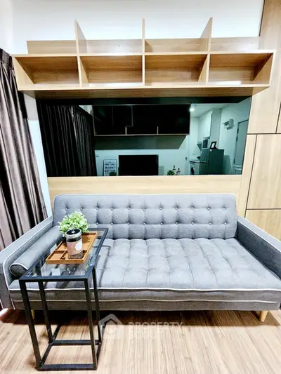 Modern living room with stylish gray sofa and wooden shelving