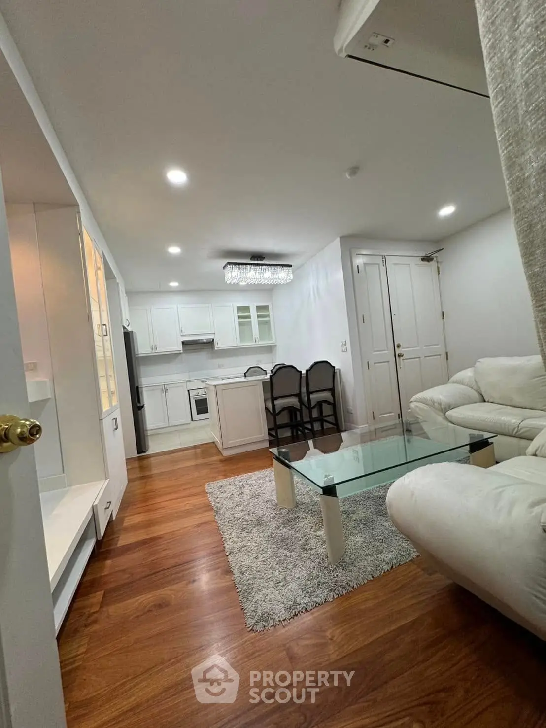 Modern open-layout living room with elegant kitchen and stylish furnishings.