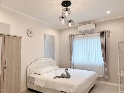 Elegant bedroom with modern decor and natural light, featuring a stylish bed and chic lighting.