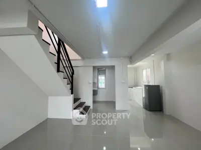 Spacious modern interior with sleek staircase and glossy tiled flooring, perfect for contemporary living.