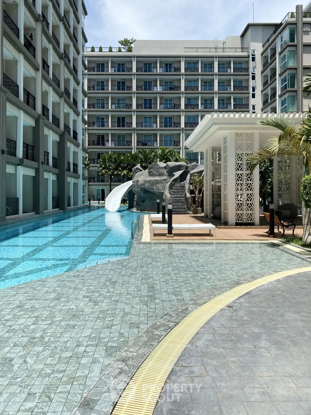 Luxurious apartment complex with stunning pool and slide, perfect for relaxation and leisure.