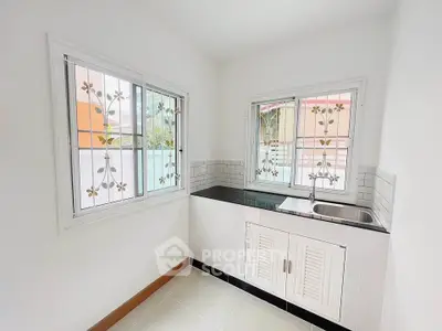 Bright kitchen with white cabinets and decorative window grills