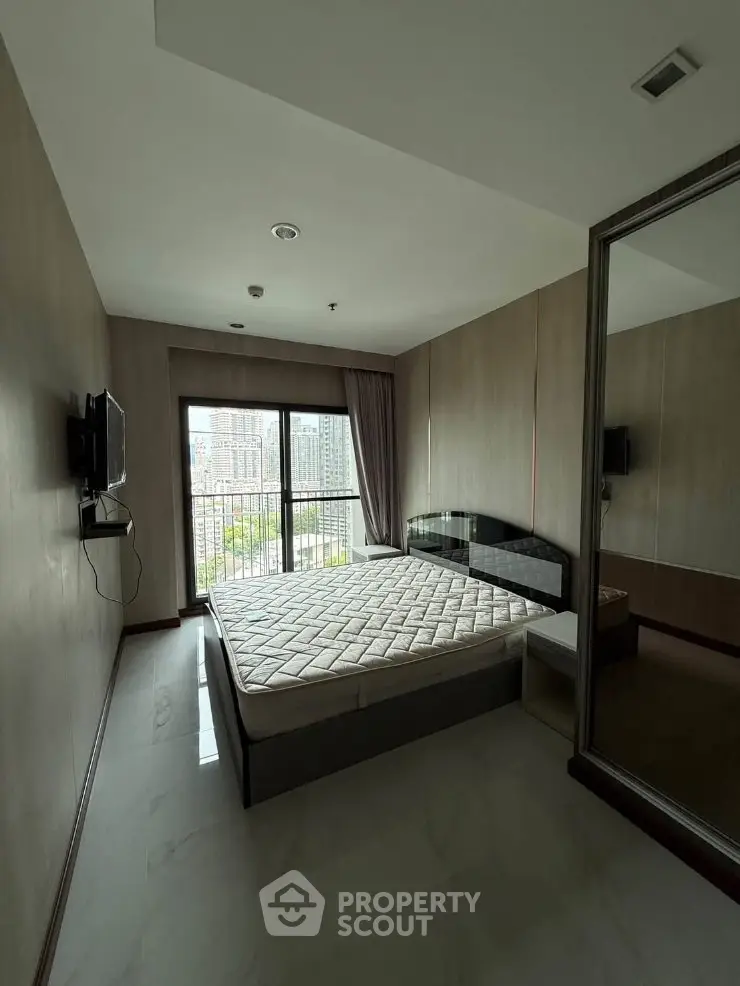 Modern bedroom with large window and city view, featuring a sleek design and ample natural light.