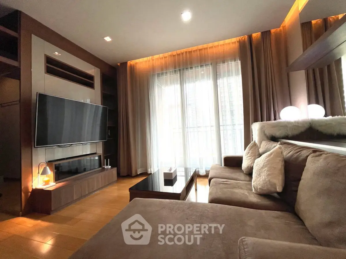 Luxurious living room with plush sofa and modern entertainment setup, featuring floor-to-ceiling windows and elegant lighting.