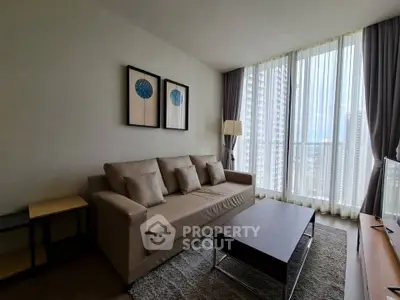 Modern living room with large windows and stylish decor in high-rise apartment.