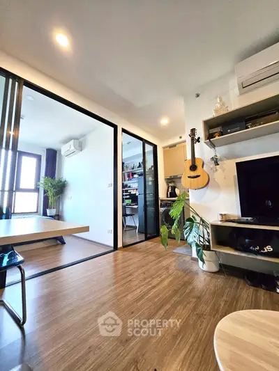 Modern living room with wooden flooring, sliding glass doors, and stylish decor