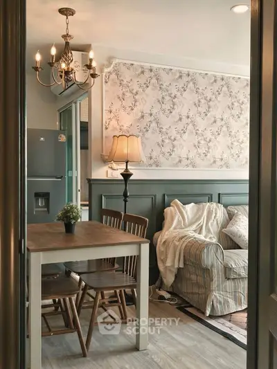 Charming living room with vintage decor, cozy sofa, elegant chandelier, and stylish wallpaper accent.