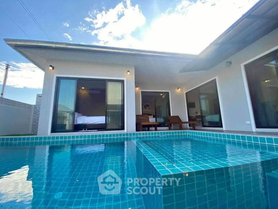 Modern villa with private pool and spacious outdoor area under clear blue sky.
