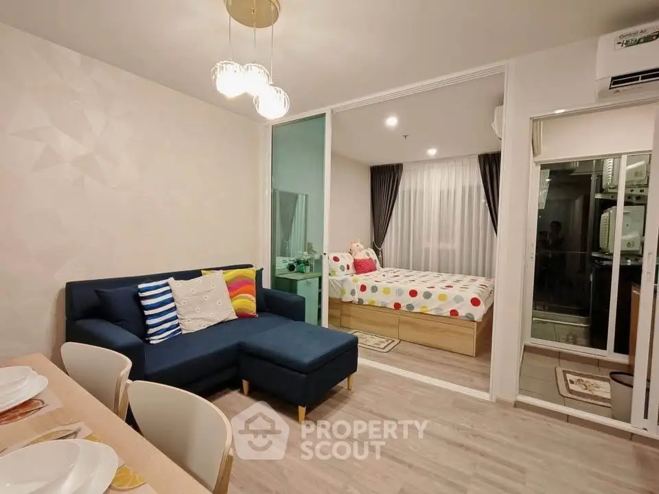 Modern apartment interior with cozy living room and stylish bedroom separated by glass wall.