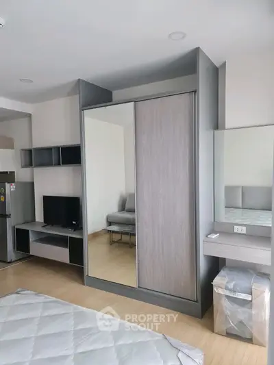 Modern bedroom with sleek wardrobe and cozy furnishings in a stylish apartment.