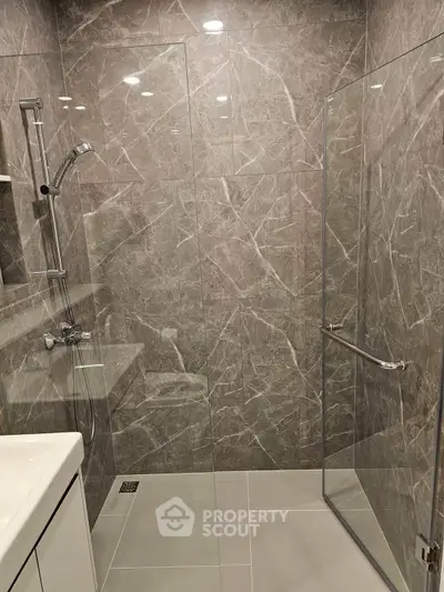 Modern bathroom with sleek glass shower and elegant marble tiles