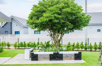Charming garden area with modern benches and lush greenery in a serene residential setting.