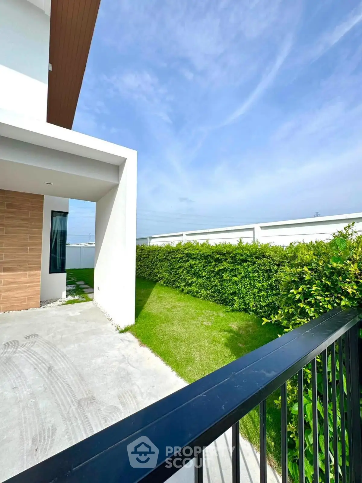 Modern house exterior with lush green lawn and sleek design, perfect for contemporary living.