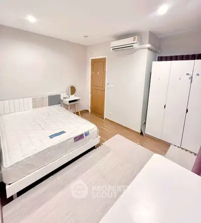 Spacious bedroom with modern furnishings and ample storage in a stylish apartment.