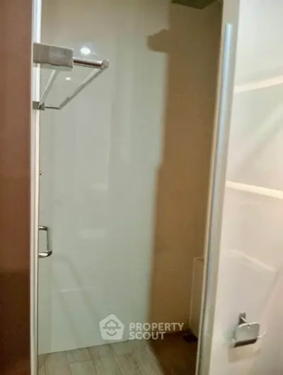 Modern bathroom with sleek shower and towel rack in contemporary home.