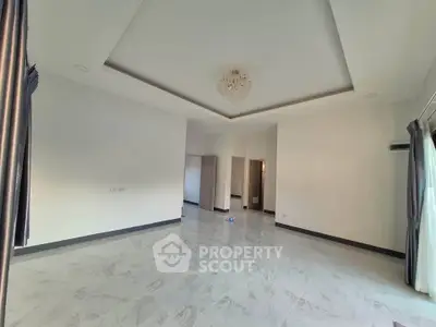 Spacious empty room with elegant ceiling design and marble flooring