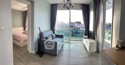 Modern living room with balcony view, featuring a cozy sofa, TV, and elegant decor.