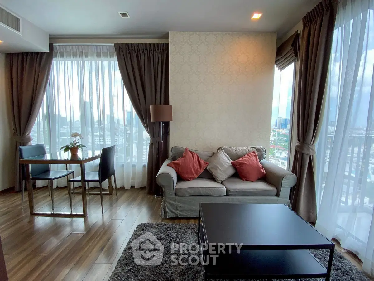 Stylish living room with panoramic city views, elegant decor, and abundant natural light in a modern apartment.