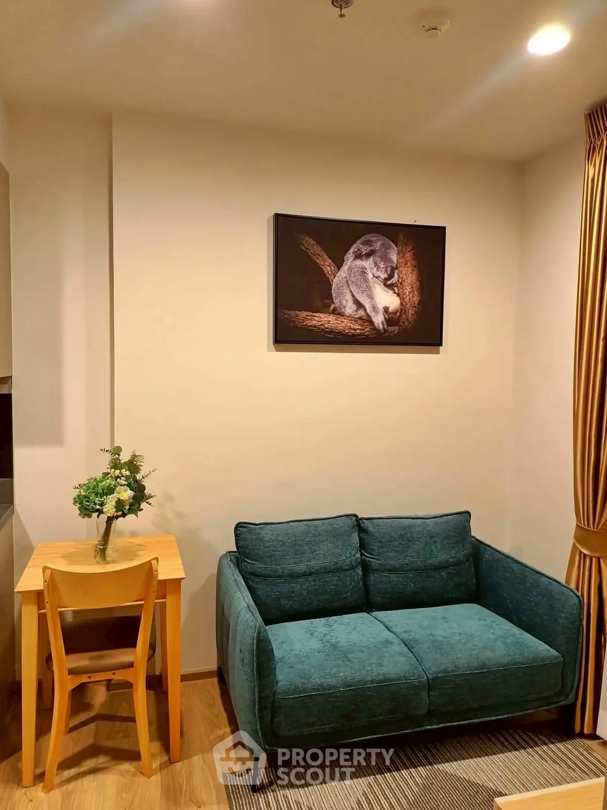Cozy living room with teal sofa and wooden furniture, perfect for relaxation.