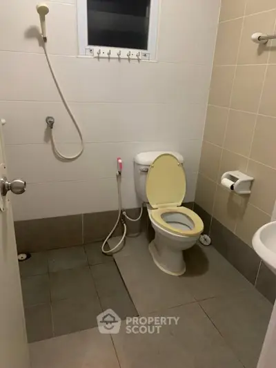 Compact bathroom with shower and toilet in neutral tones