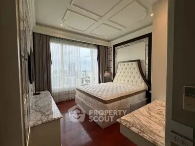 Luxurious bedroom with city view, elegant decor, and plush furnishings in a high-rise apartment.