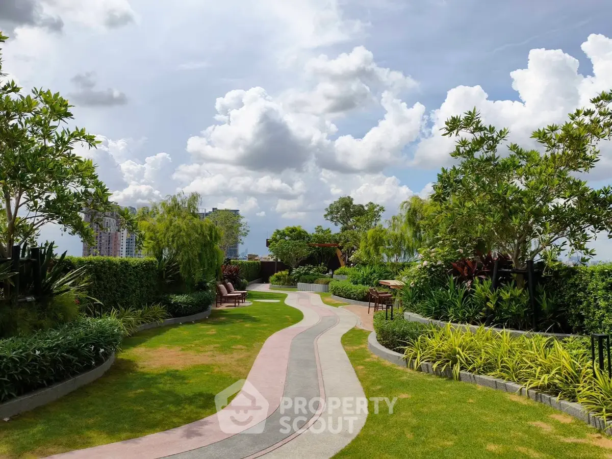 Lush garden with winding path and city skyline view, perfect for relaxation and outdoor enjoyment.