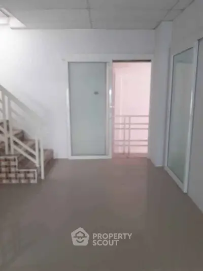Spacious interior with modern staircase and sliding glass doors, ideal for versatile use.