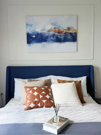 Cozy bedroom with stylish decor and abstract art above bed