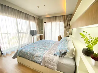 Spacious bedroom with modern decor and large windows offering abundant natural light.