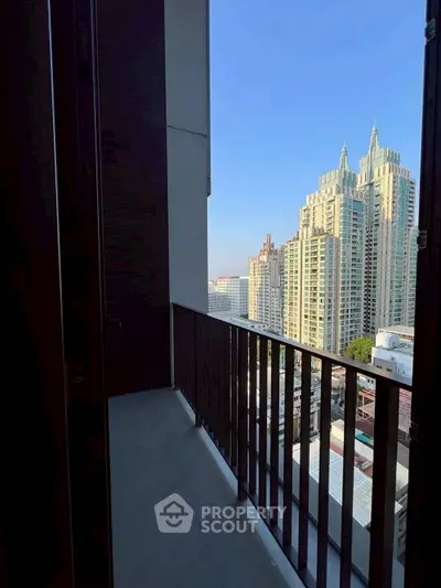 Stunning city view from a high-rise balcony with modern railing design.
