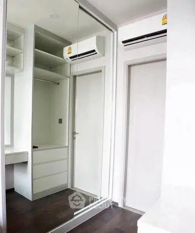 Modern bedroom with mirrored closet and air conditioning unit