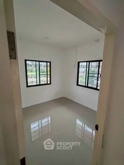 Bright empty room with large windows and glossy tiled floor, perfect for customization.