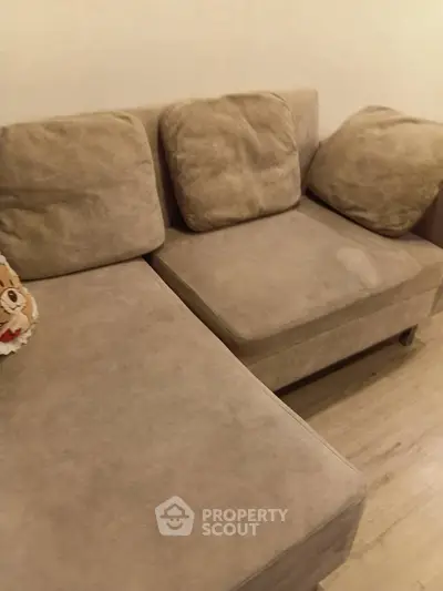 Cozy beige sectional sofa in a modern living room with wooden flooring.
