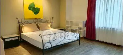 Spacious bedroom with elegant bed and large window for natural light.