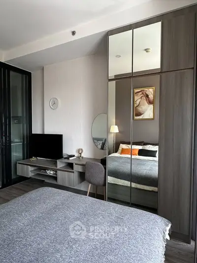 Modern bedroom with stylish decor, mirrored wardrobe, and cozy bedding in a contemporary apartment.