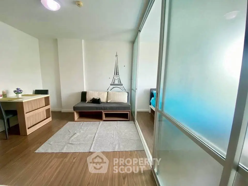 Modern living room with Eiffel Tower wall art and glass partition