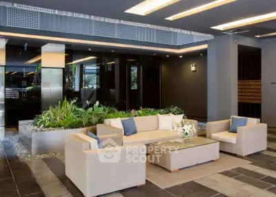 Modern building entrance with stylish seating and indoor garden