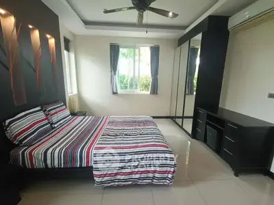 Spacious bedroom with modern decor and large window offering natural light.