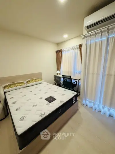 Modern bedroom with stylish decor and natural light, featuring a comfortable bed and air conditioning.
