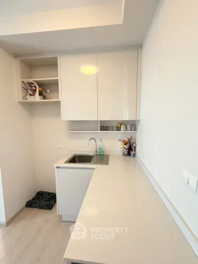 Modern minimalist kitchen with sleek white cabinetry and spacious countertop