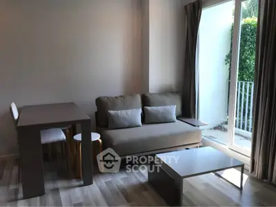 Modern living room with sleek furniture and natural light from large window.