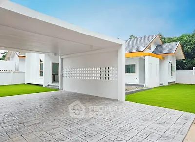 Modern single-story home with spacious driveway and lush green lawn