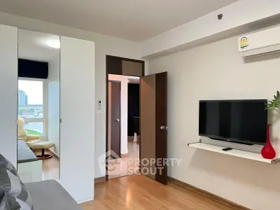 Modern living room with TV, air conditioning, and city view from window.