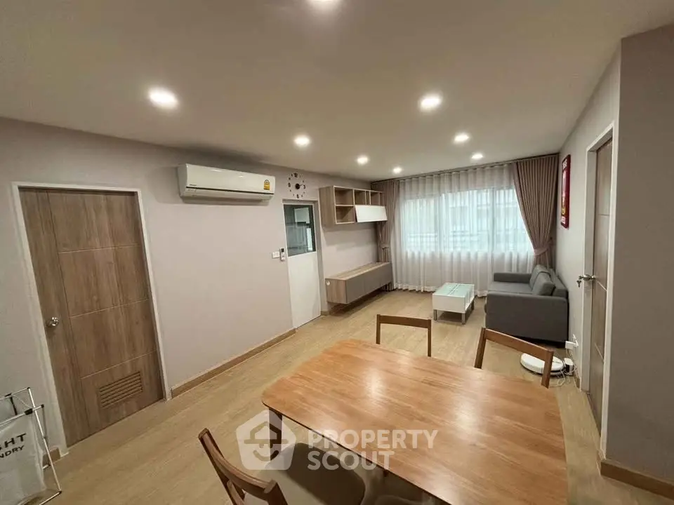Modern living room with wooden furniture and ambient lighting in a cozy apartment.