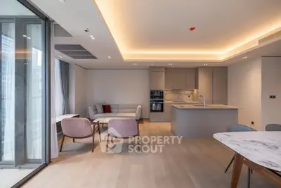 Modern open-plan living room with sleek kitchen and stylish furniture in luxury apartment.