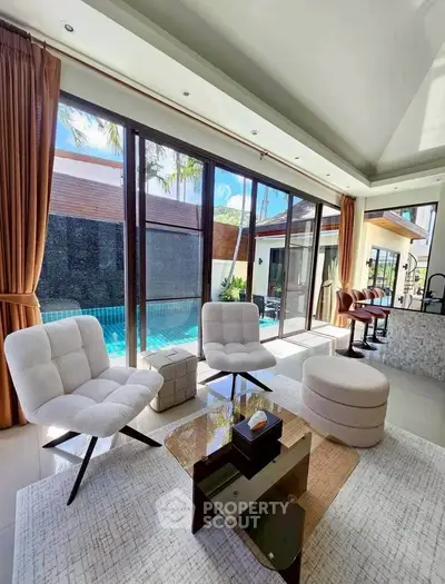 Luxurious living room with pool view, modern furniture, and large windows in a contemporary home.