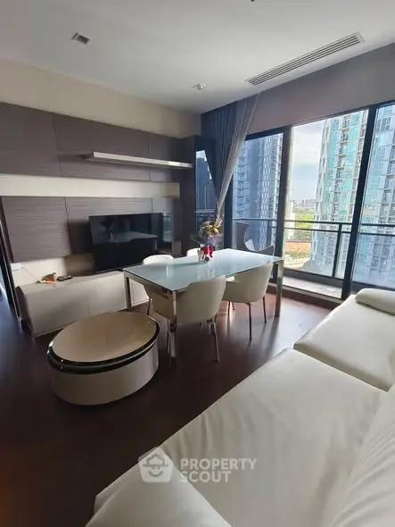Modern living room with large windows and city view, featuring sleek furniture and elegant decor.