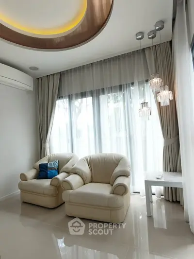 Elegant living room with plush seating and modern lighting, featuring floor-to-ceiling windows and stylish decor.