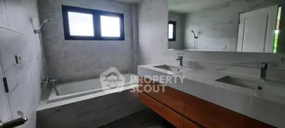 Modern bathroom with dual sinks and bathtub in stylish real estate property.